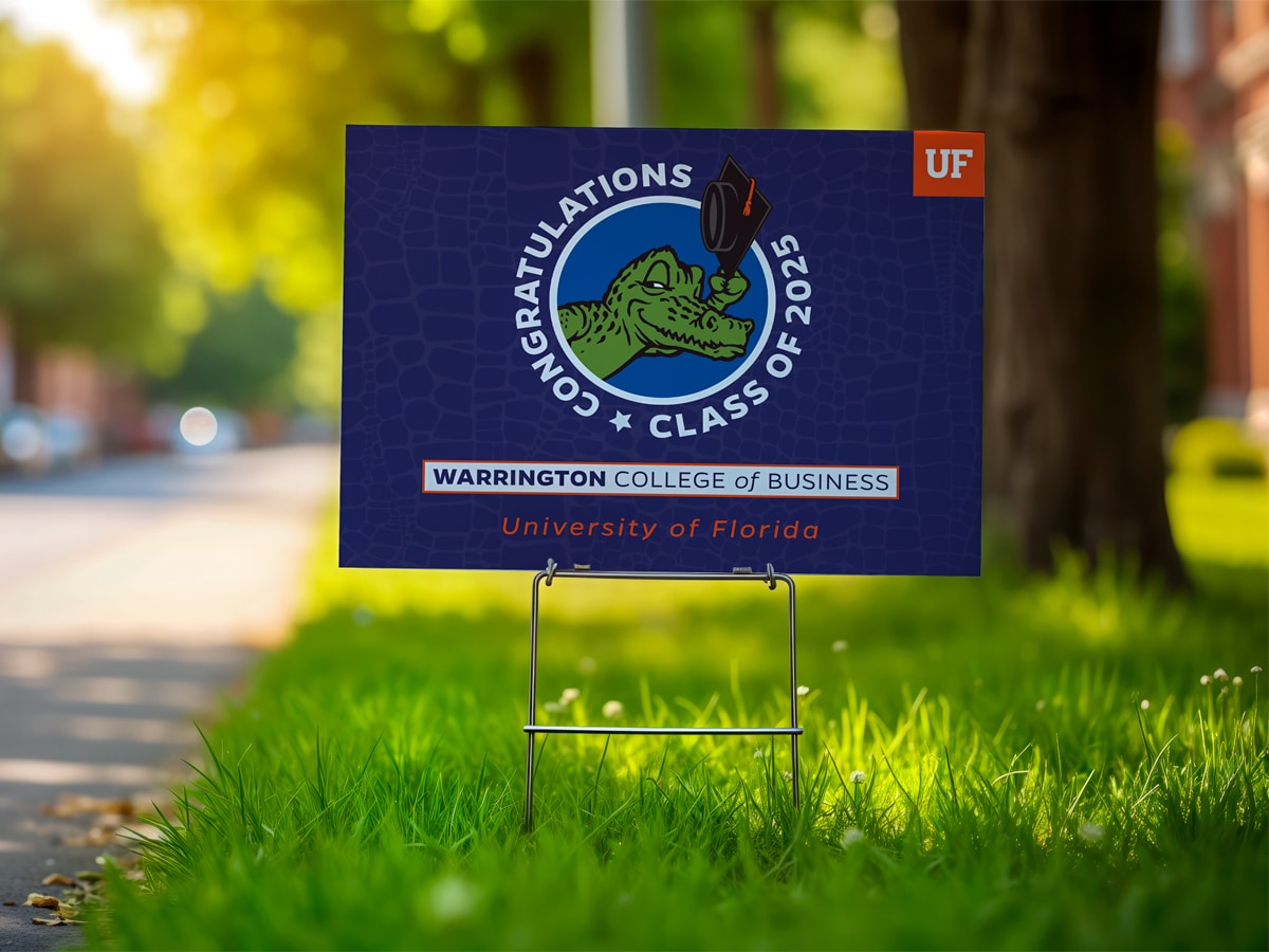 A lawn sign staked in grass featuring the UF alligator wearing a graduation cap and the text “Congratulations Class of 2025” above “Warrington College of Business – University of Florida.”