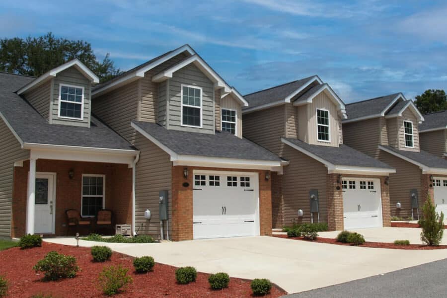 A row of new townhouses with garages along a street