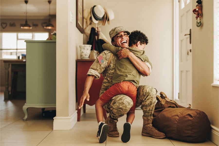 Military parent in uniform embraces child at homecoming