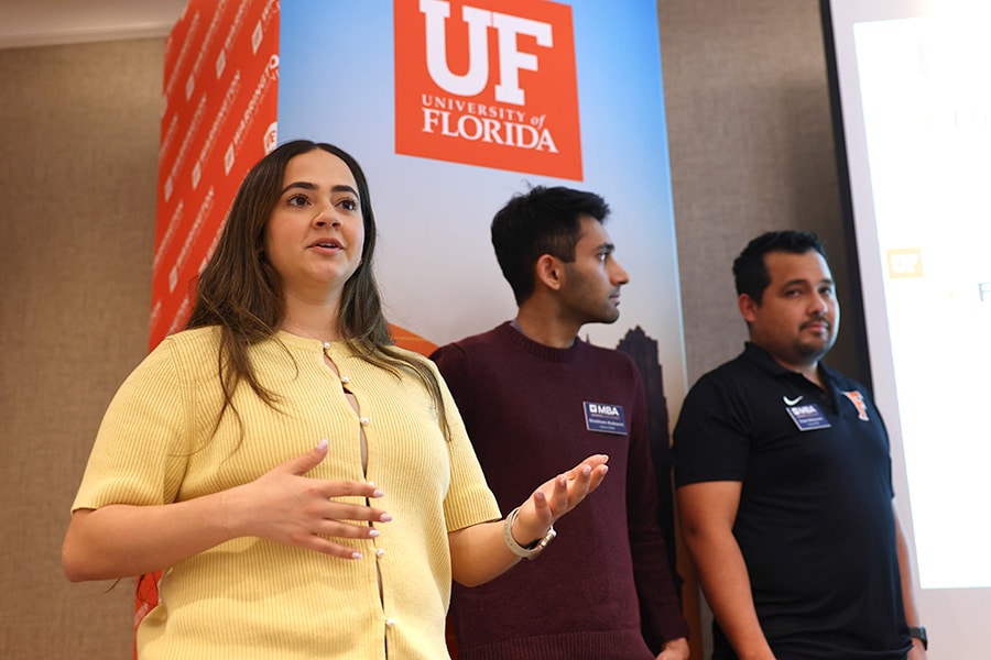 Three MBA students presenting a group project.