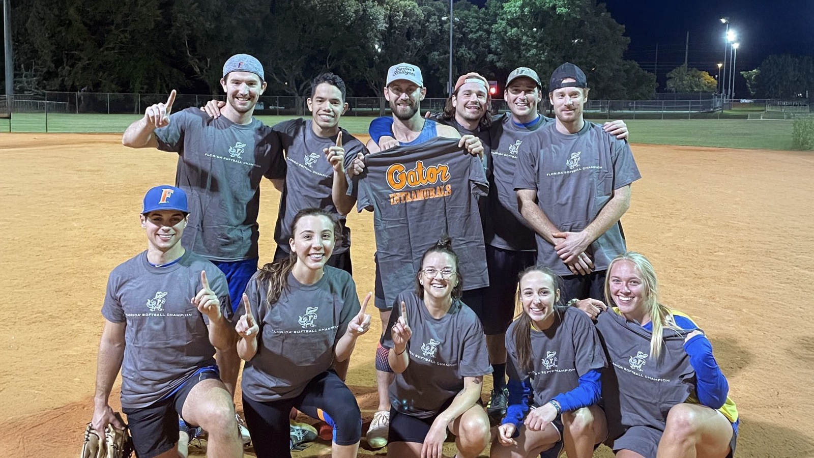 UF MBA students pose as a team on a softball field after an intramural game victory