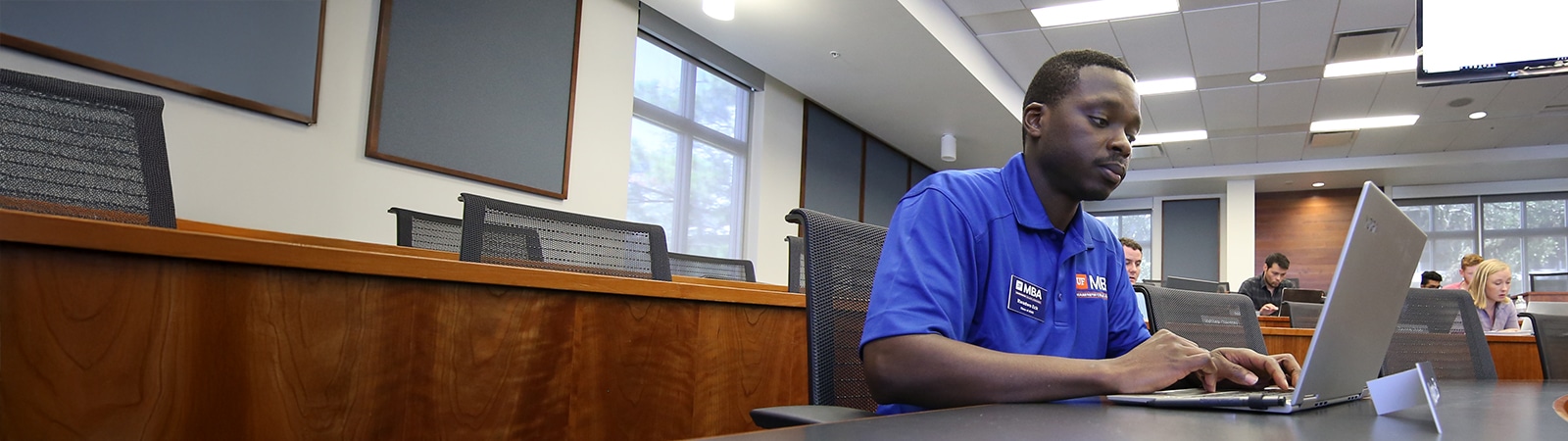 MBA student using a laptop in a classroom