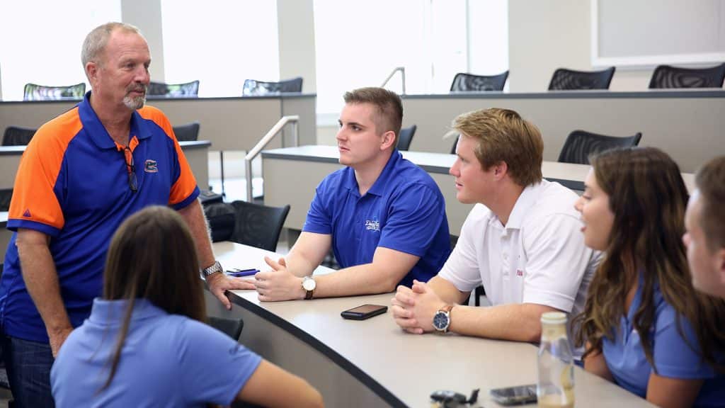 A professor working with students in a classroom. 