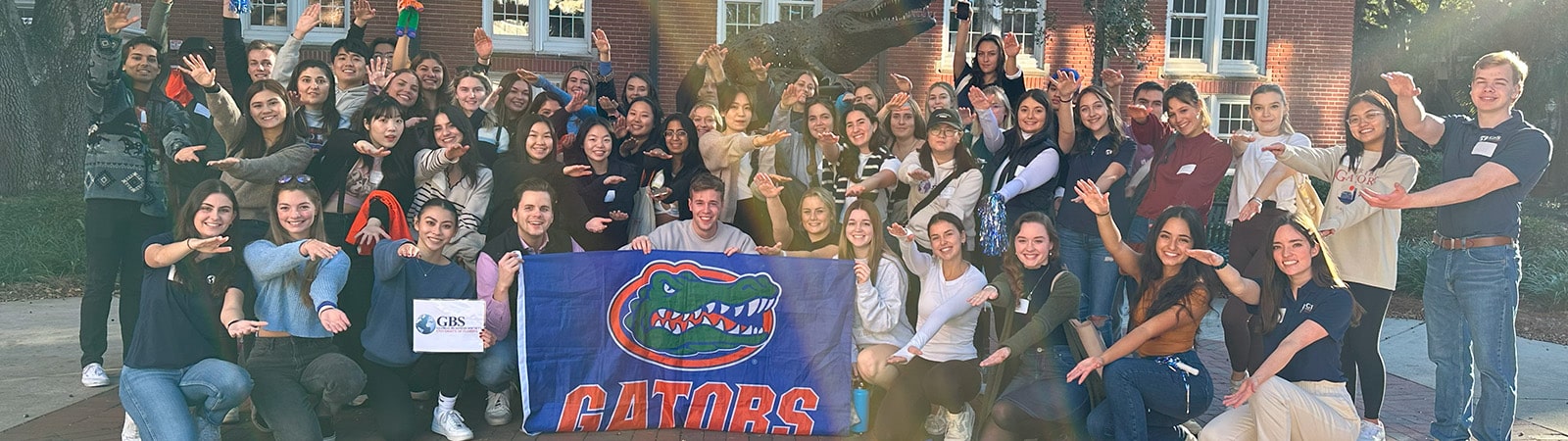 Group photo of the Global Business Society members in front of a gator statue.