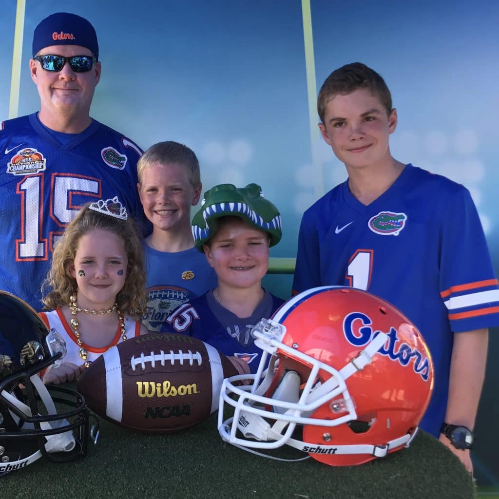 Liam O'Neil and his four children in their Gator gear with a football helmet in the foreground. 