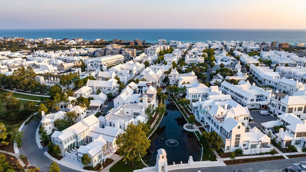 An aerial photo of the Alys community with white roofs and walls along the Florida Gulf Coast, visible in the background.