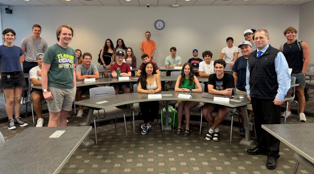 group picture with students sitting at desks and standing with Steven Morrison from CohnReznick
