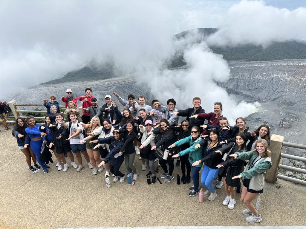 Nandini Kumar and her team doing the Gator chomp outside a geyzer