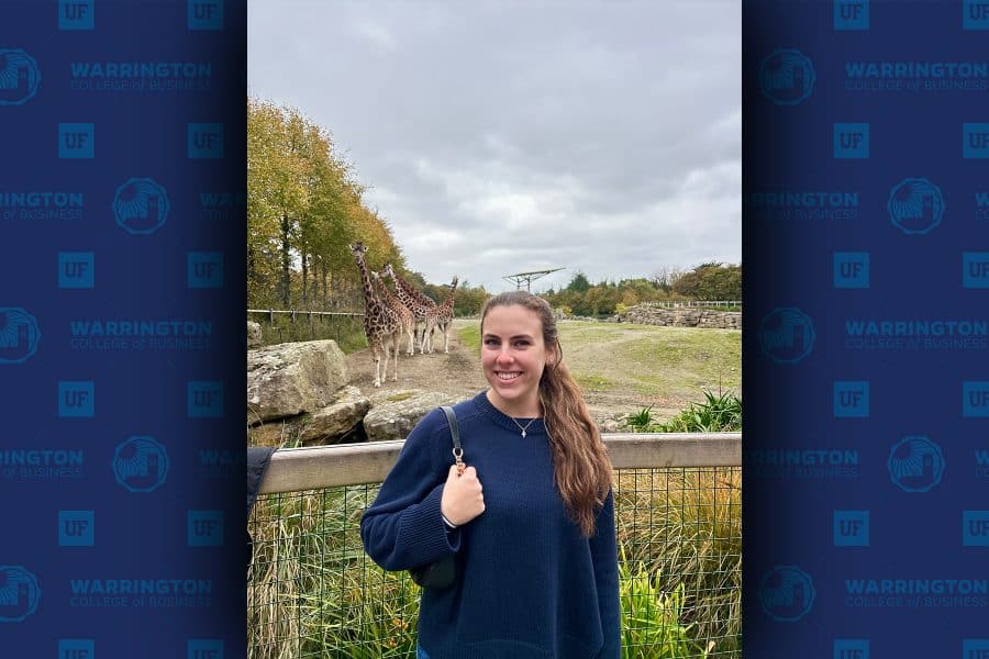 Carly Rutigliano standing in front of a giraffe smiling