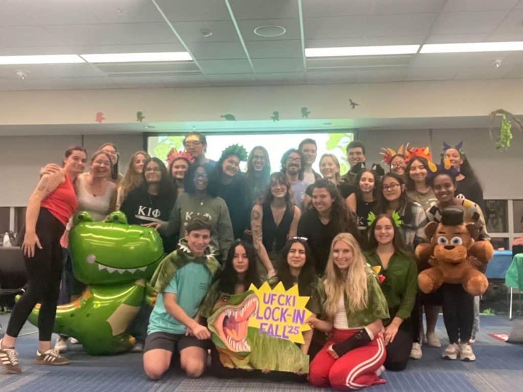 Angelina Boughanem poses with fellow CKI members for a group photo with a sign that says "UF CKI Lock-In Fall '25"