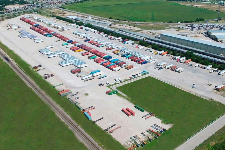 An aerial view of an industrial storage facility where many trucks and storage containers are parked