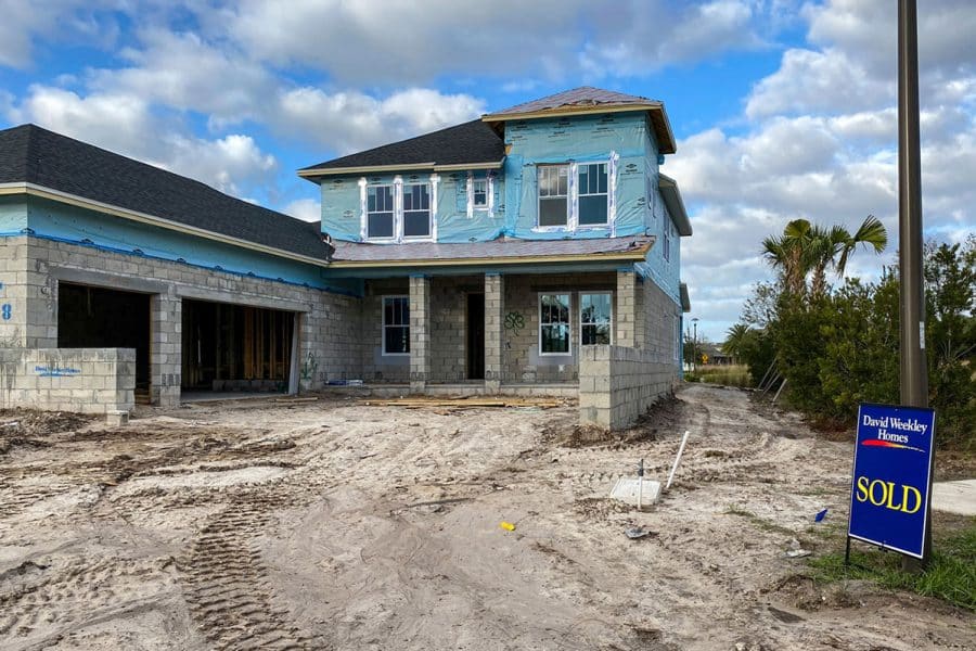 A house under construction with a sold sign out front