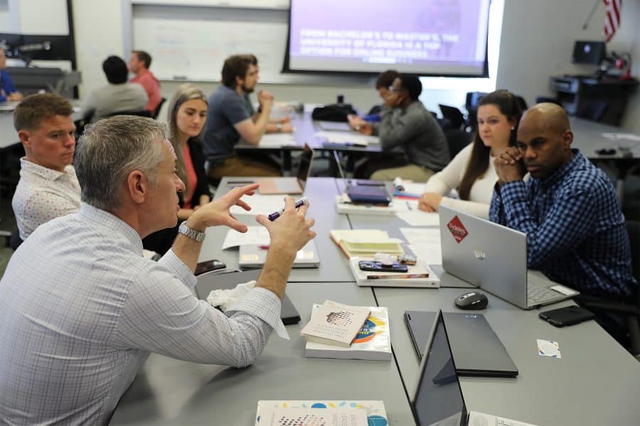Professor speaks with table of Warrington students.